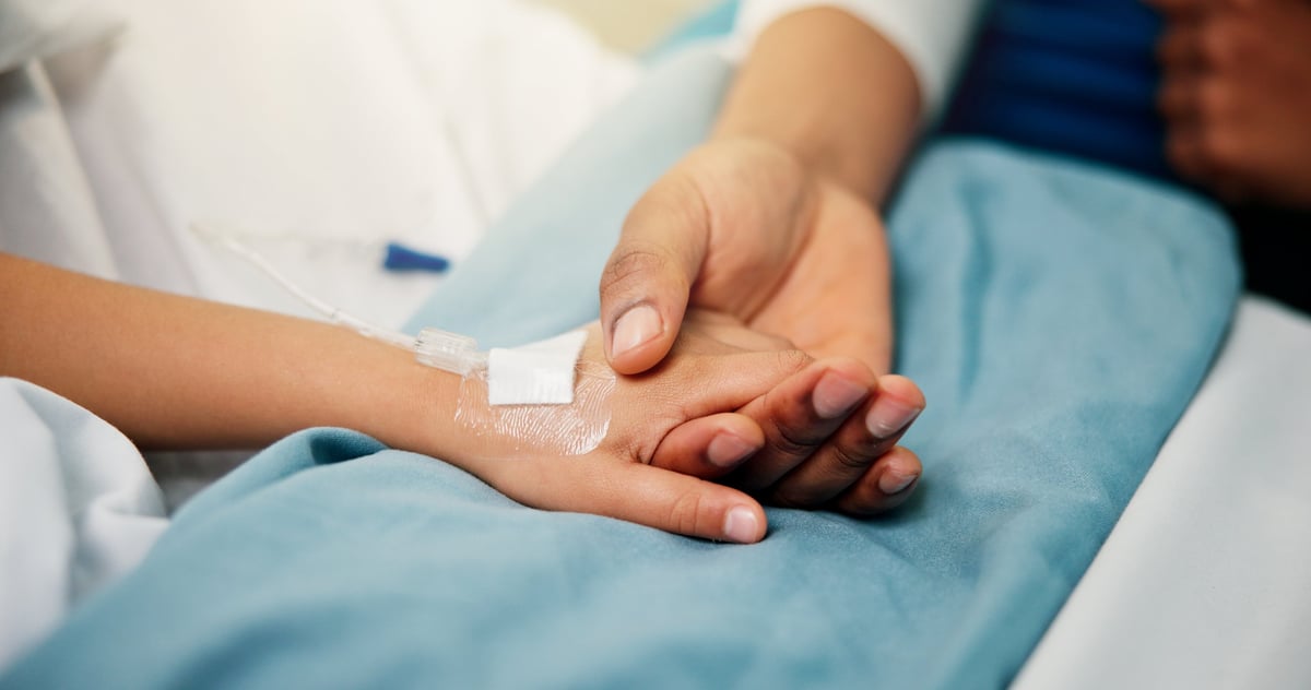 A person holding hands with a family member during recovery, showing comfort and support
